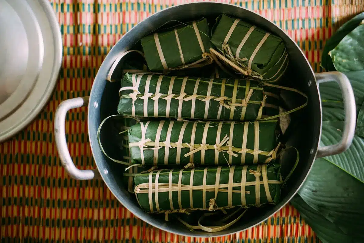 Plats traditionnels cambodgiens incluant amok de poisson et curry avec riz, herbes fraîches