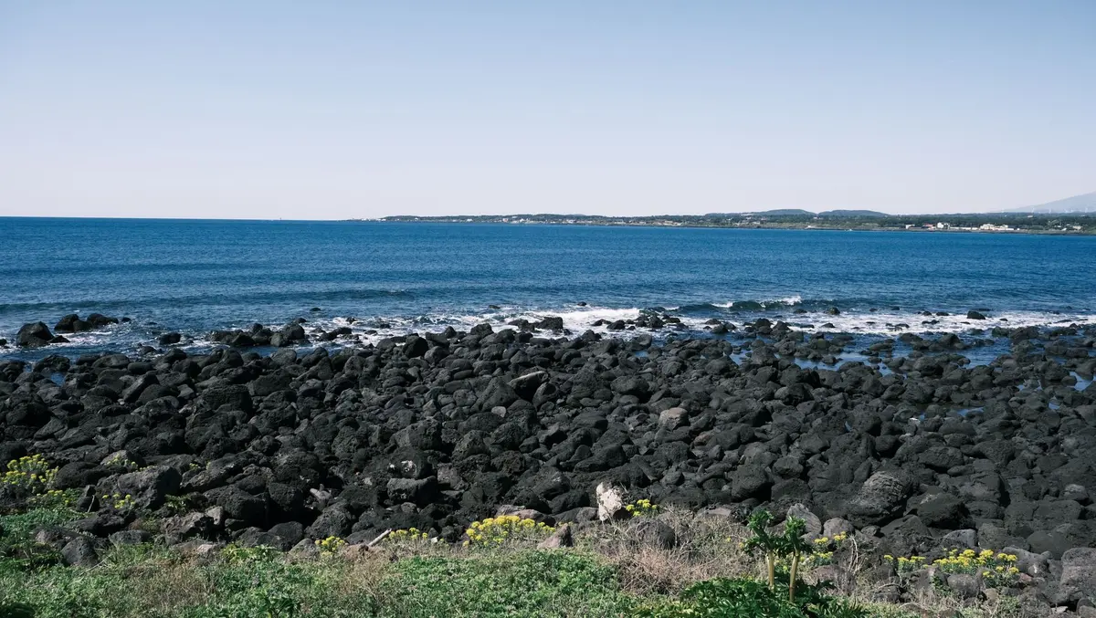 Paysage volcanique de l'île de Jeju avec formations rocheuses et panorama marin spectaculaire