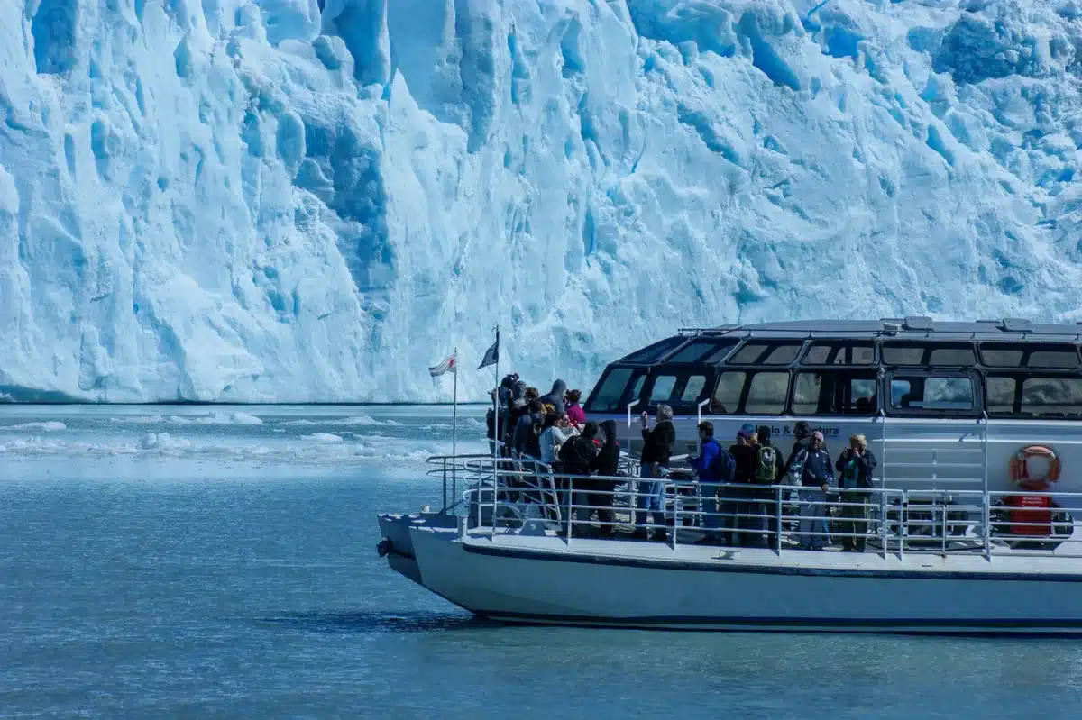 Groupe de randonneurs en bateau approchant des icebergs dans l'Arctique