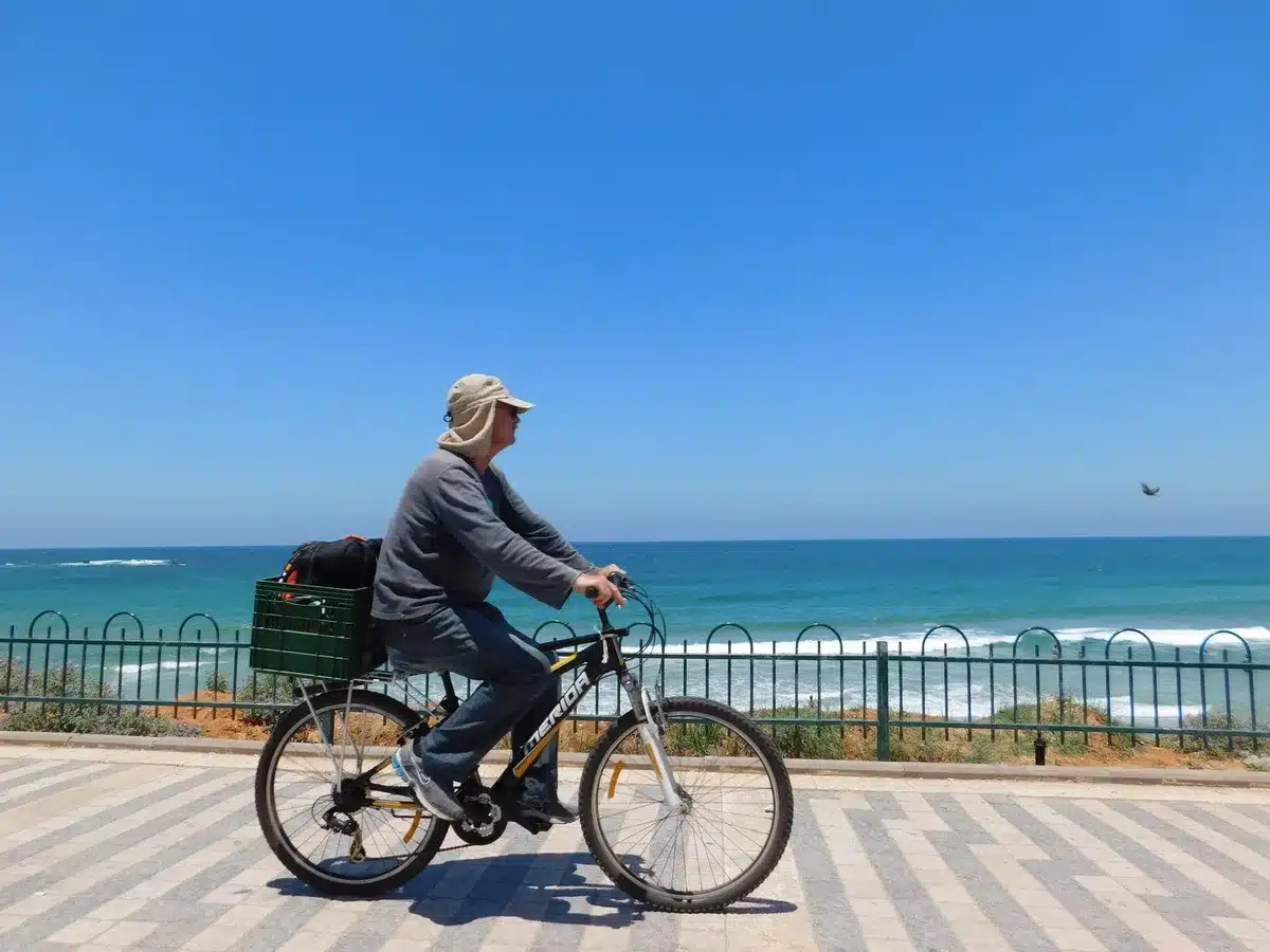 Cycliste sur une piste côtière près de la mer, représentant la mobilité douce en ville littorale