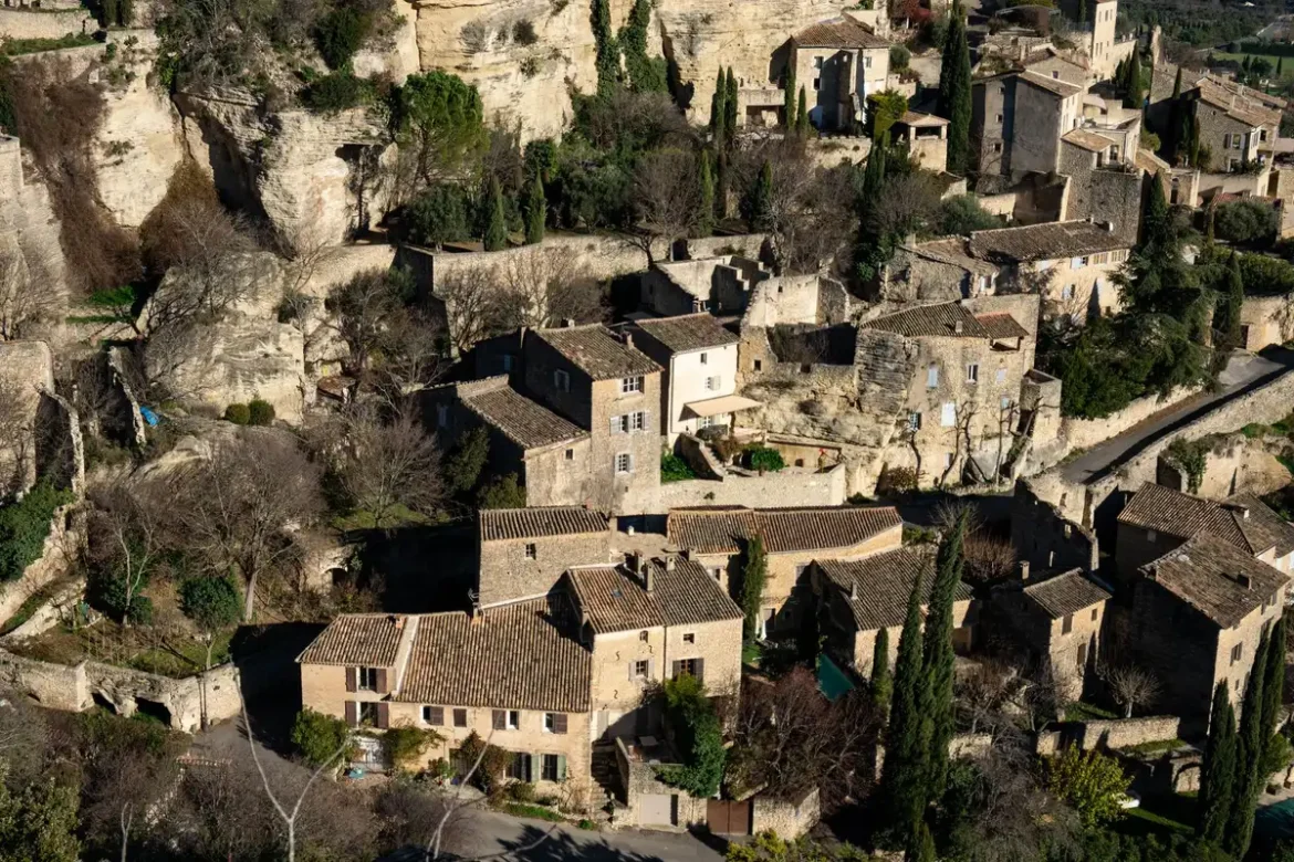 Place historique d'une petite ville provençale avec bâtiments en pierre et terrasses de café