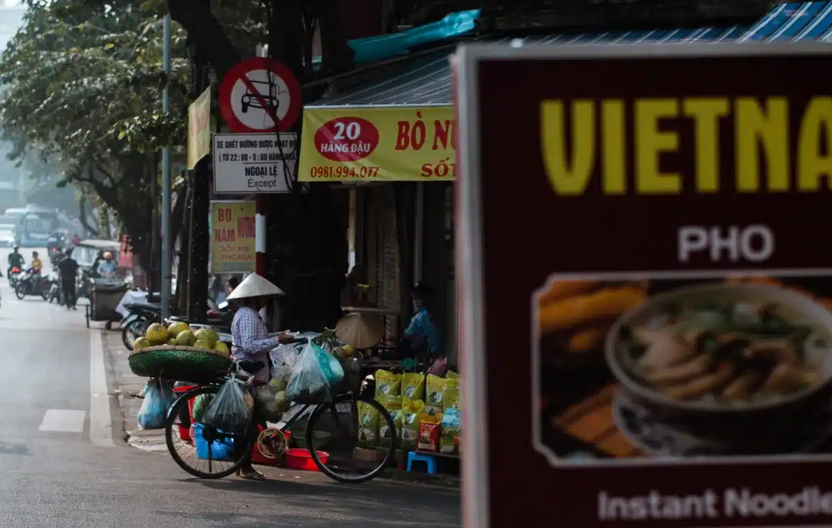 Ruelle animée de Hanoi avec vendeurs de rue et habitants locaux