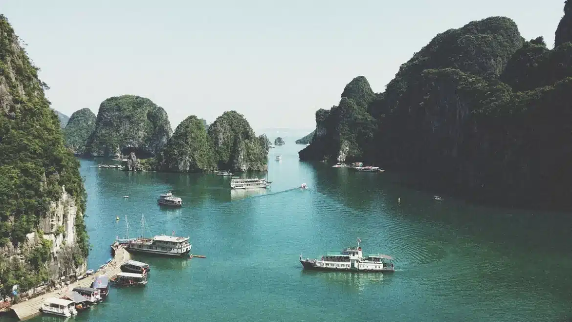 Jonque traditionnelle naviguant entre les îlots calcaires d'une baie tropicale