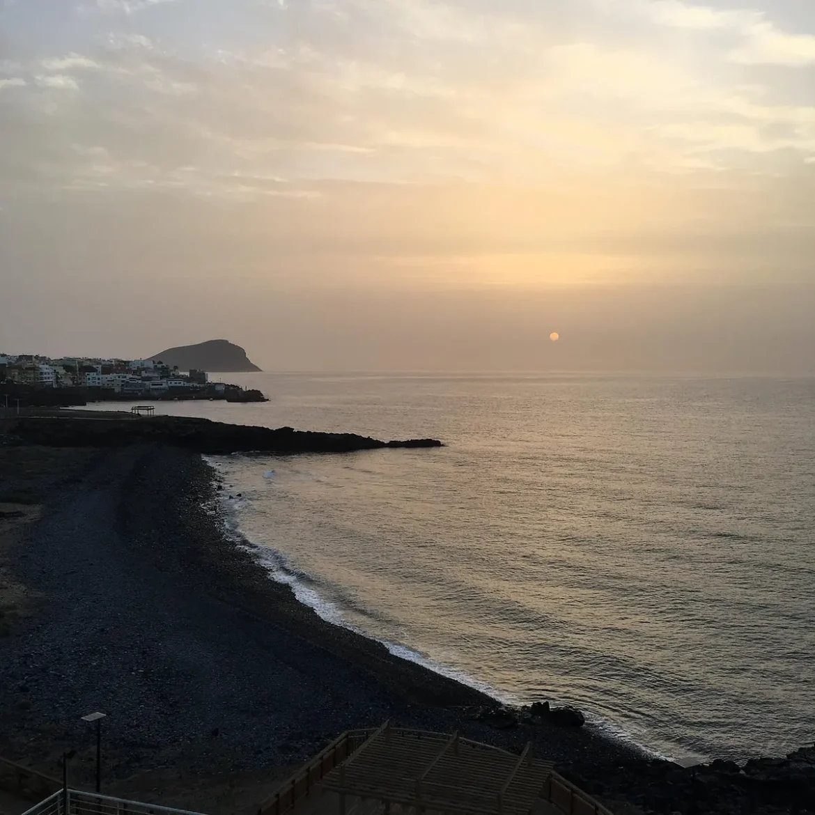 Promeneurs anonymes sur des remparts de granit avec vue sur l'Atlantique