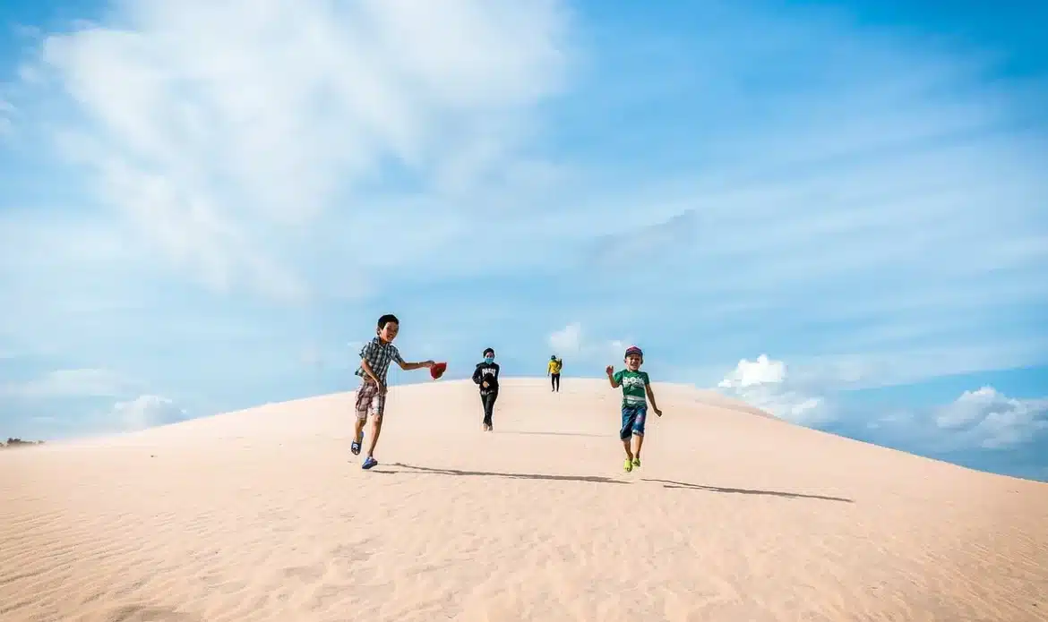 Paysage désertique avec dunes dorées, mer turquoise à l'horizon et lumière hivernale généreuse