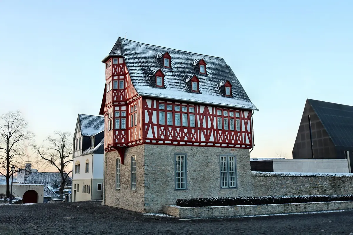 Façades colorées en pans de bois le long d'une rue pavée à Beuvron-en-Auge