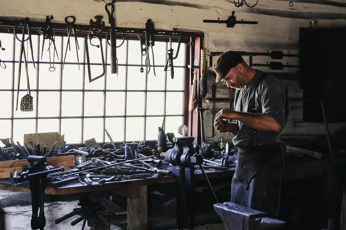 Artisan travaillant dans un atelier ouvert au public, outils et pièce en cours