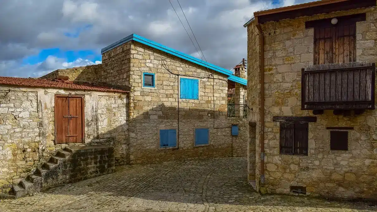 Ruelle pavée d'un village savoyard aux façades fleuries en plein jour