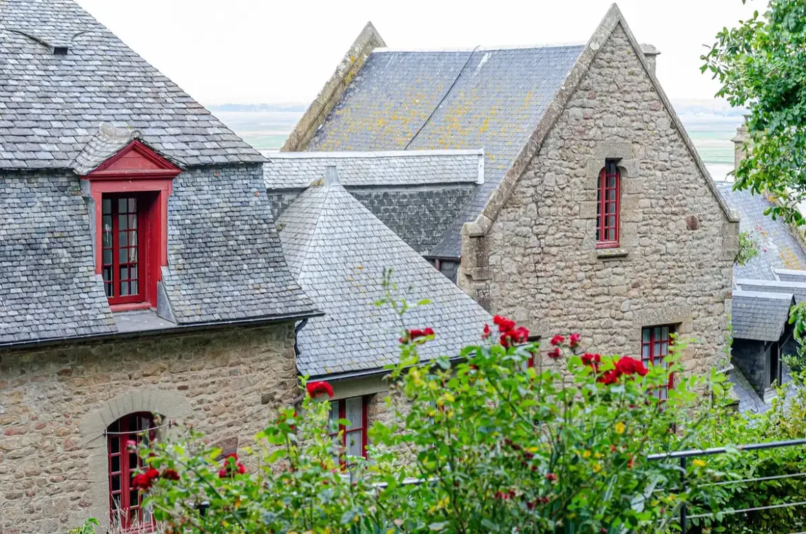 Vue diurne des coteaux et ruelles de village près d'une abbaye, vignobles en arrière-plan