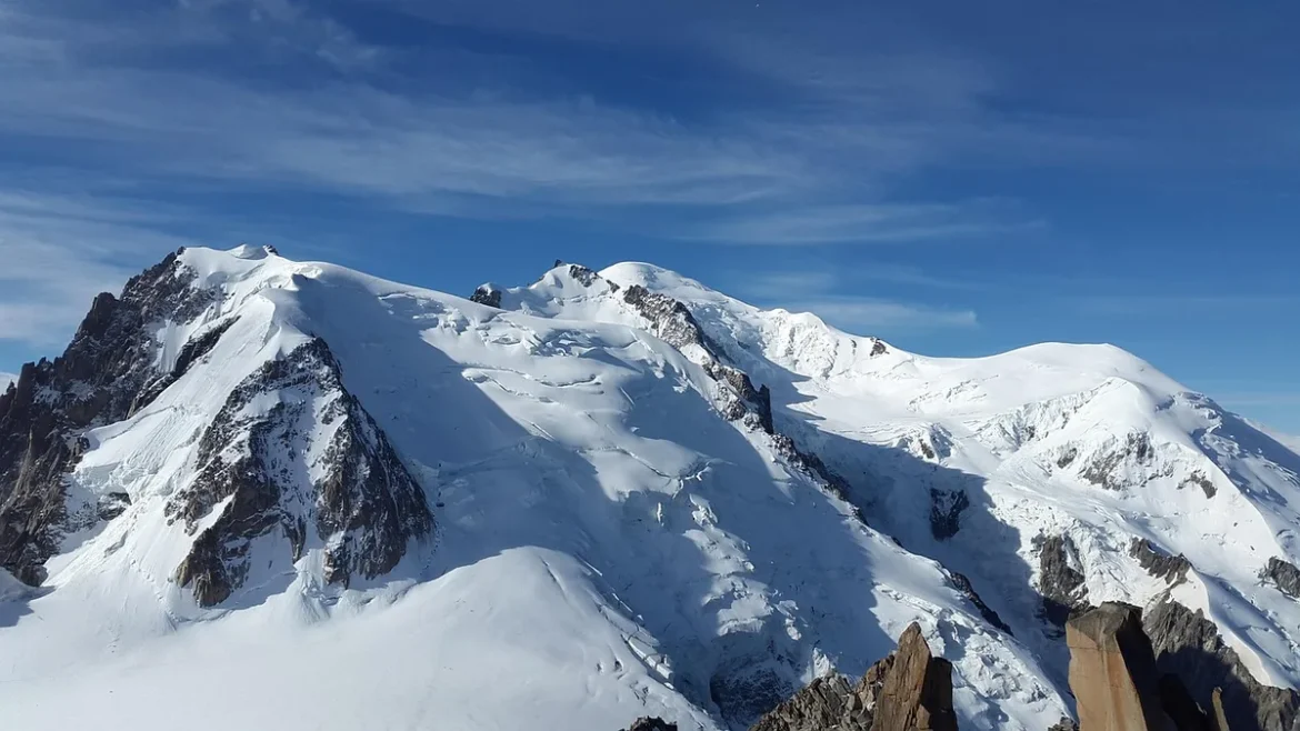 Vue diurne d'un village de montagne avec chalets et le Mont‑Blanc en arrière‑plan