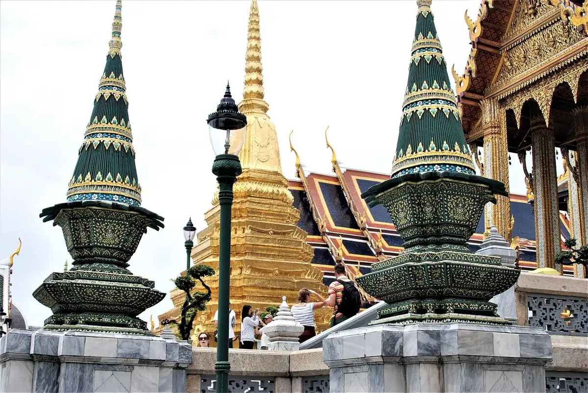 Bateau sur le Chao Phraya proche d'un marché et d'un temple à Bangkok